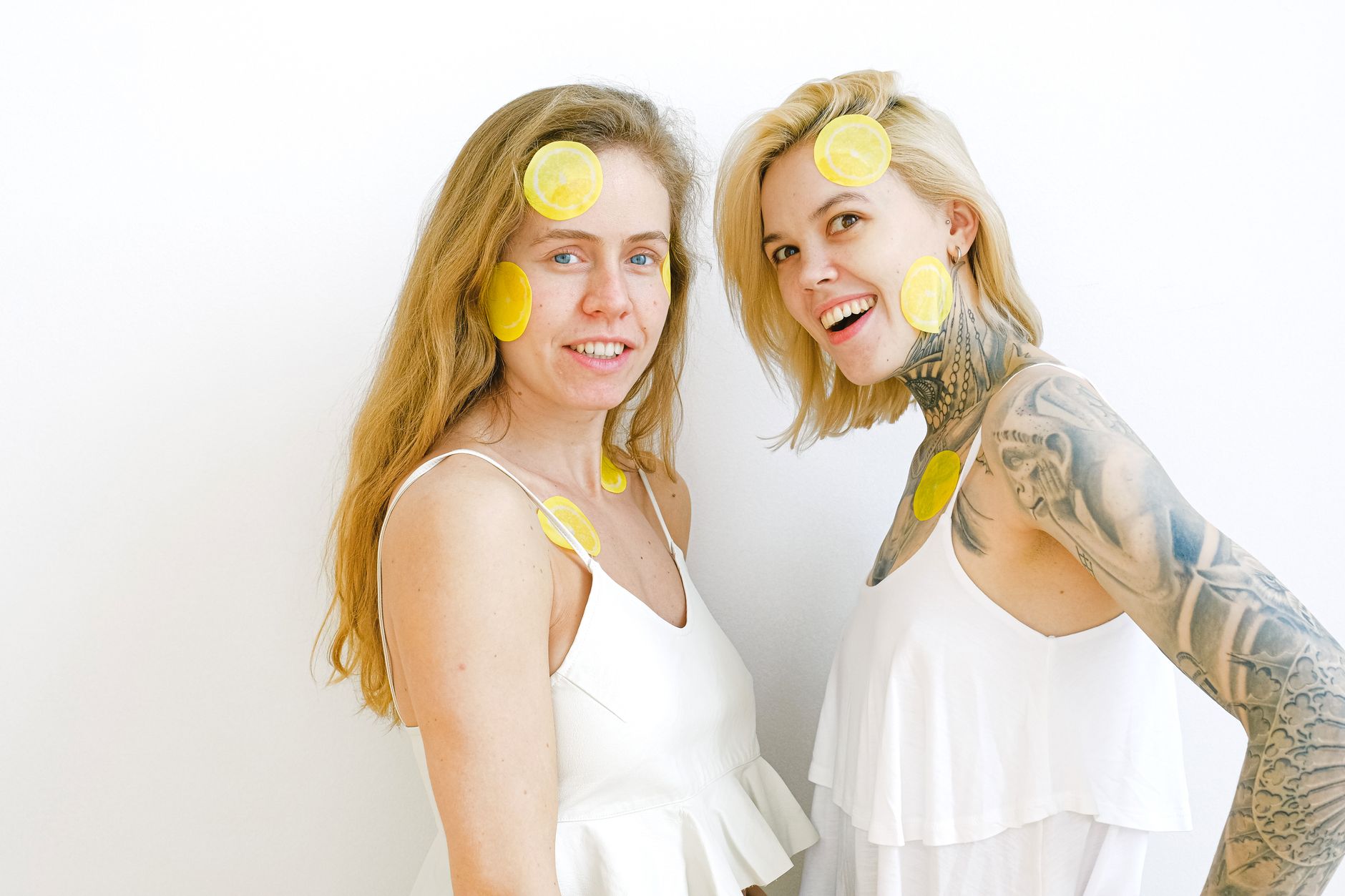 Yellow silicone vibrator surrounded by fresh fruit on a bright yellow background