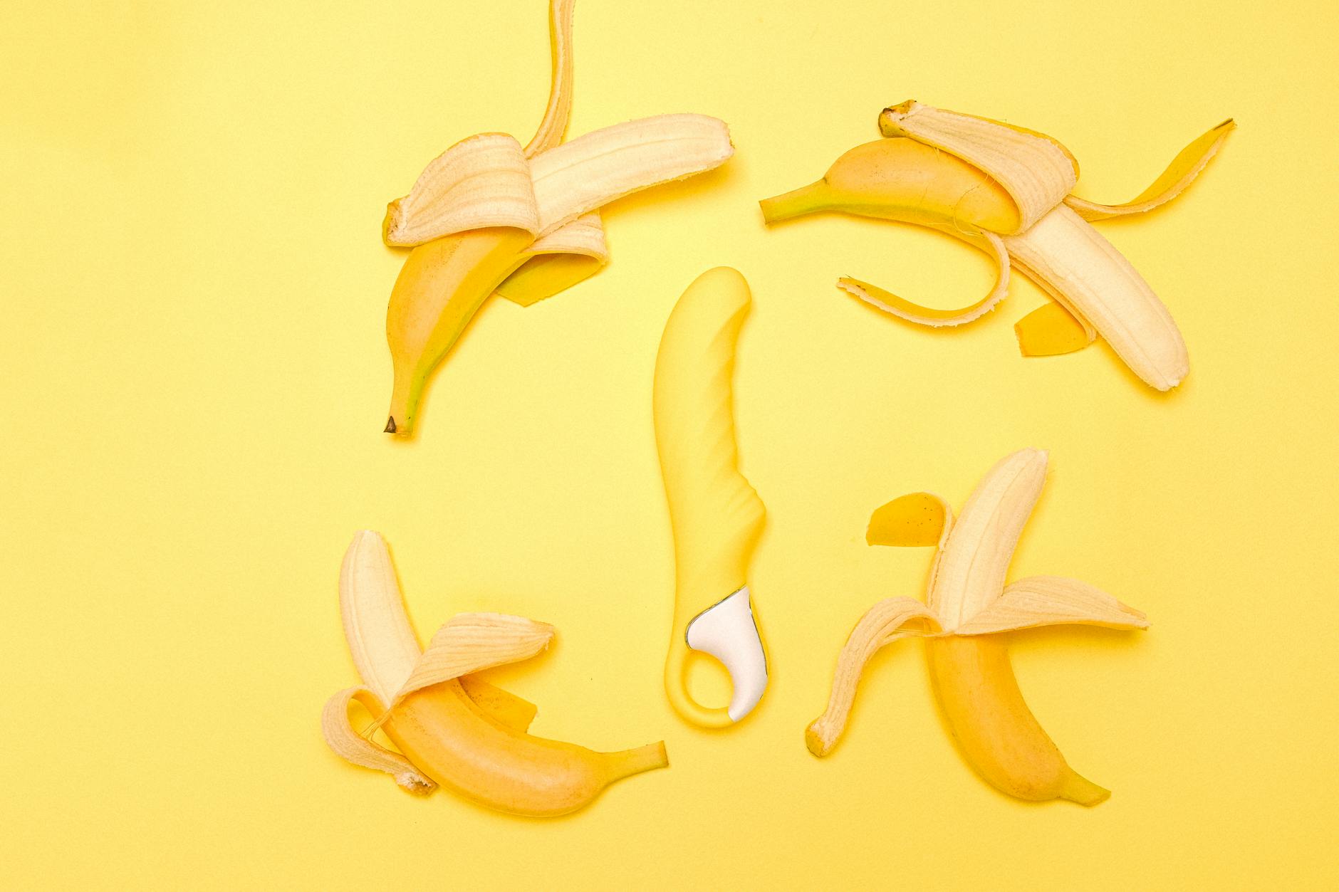 A yellow lemon vibrator surrounded by fresh lemons on a bright yellow background, symbolizing the Lem's intuitive design.