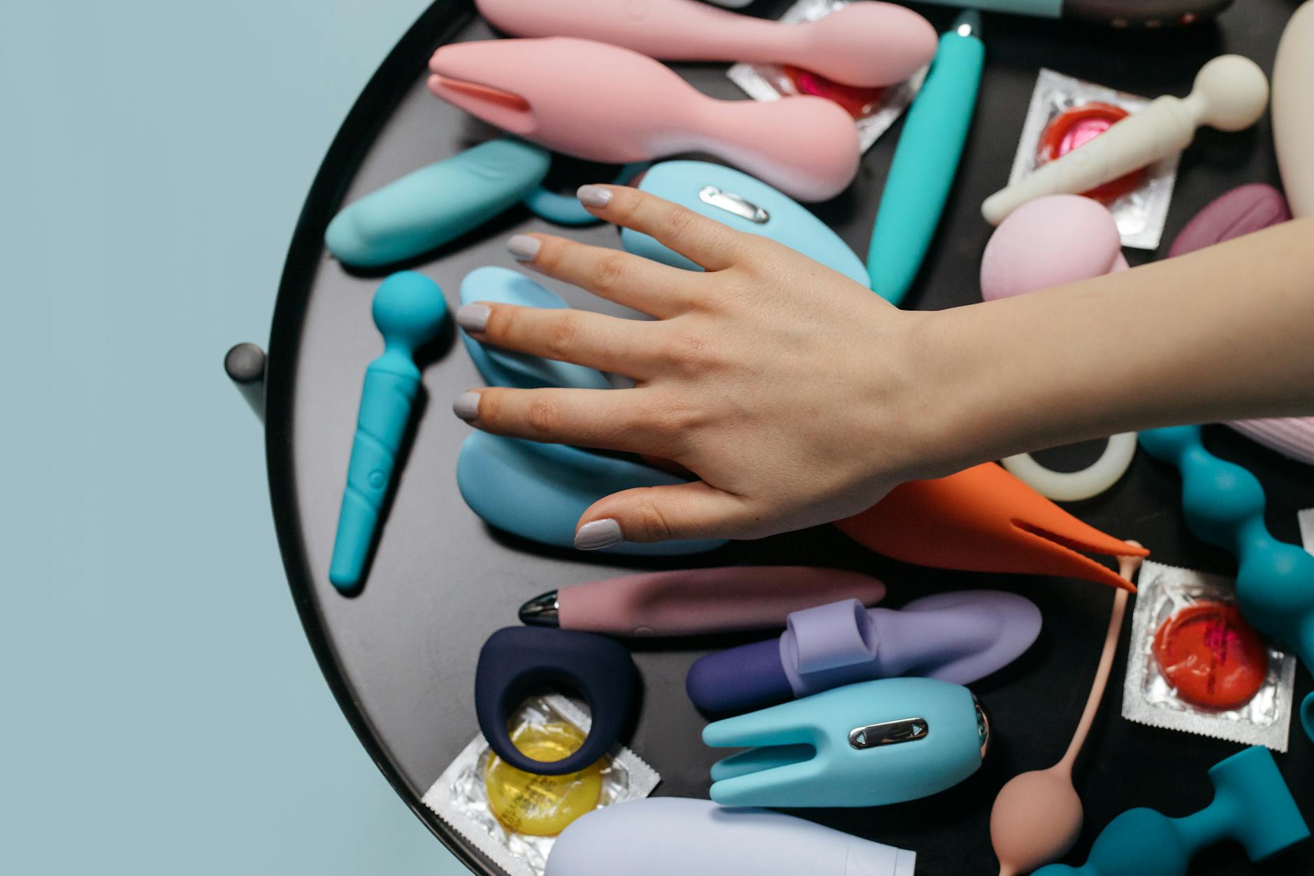 A blue silicone vibrator held in hand against a purple background, symbolizing reconnection and self-awareness