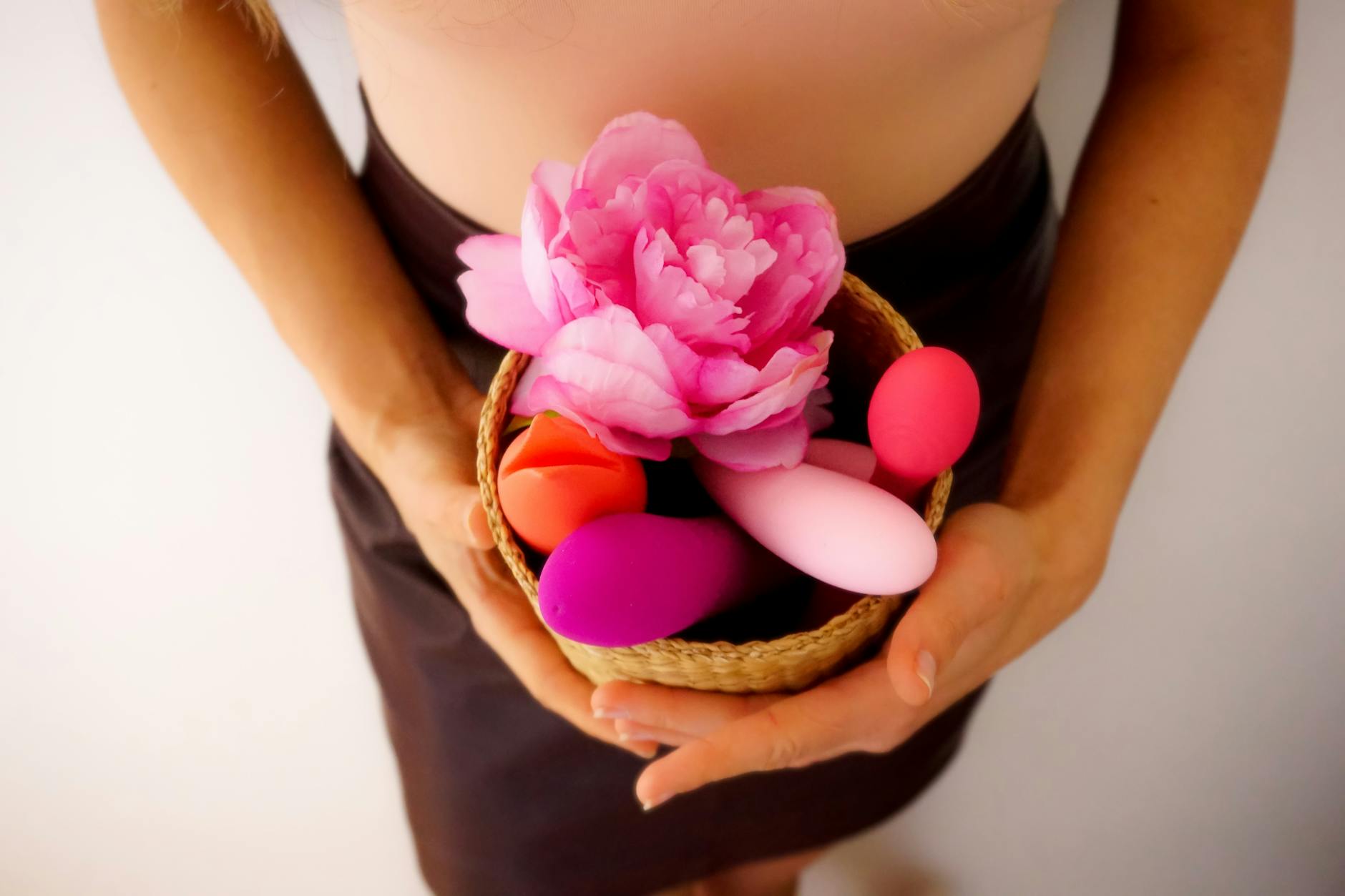 Hands holding silicone vibrators in various colors, symbolizing intimate wellness and pleasure reconnection